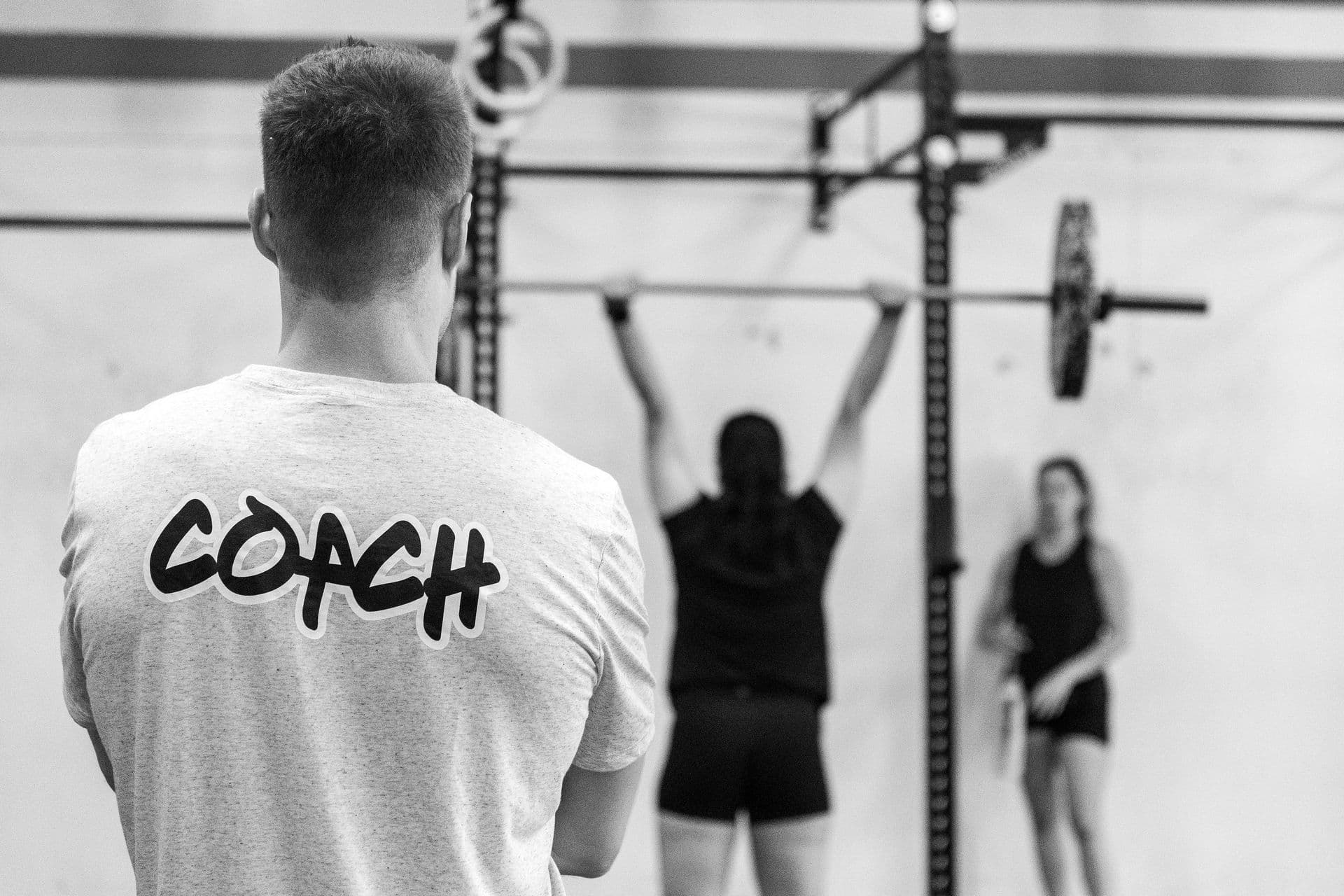 A coach watches members work at the rig during a class at CrossFit Max.